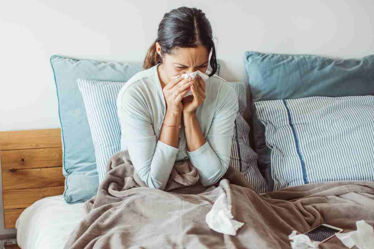 donna che si soffia il naso a letto