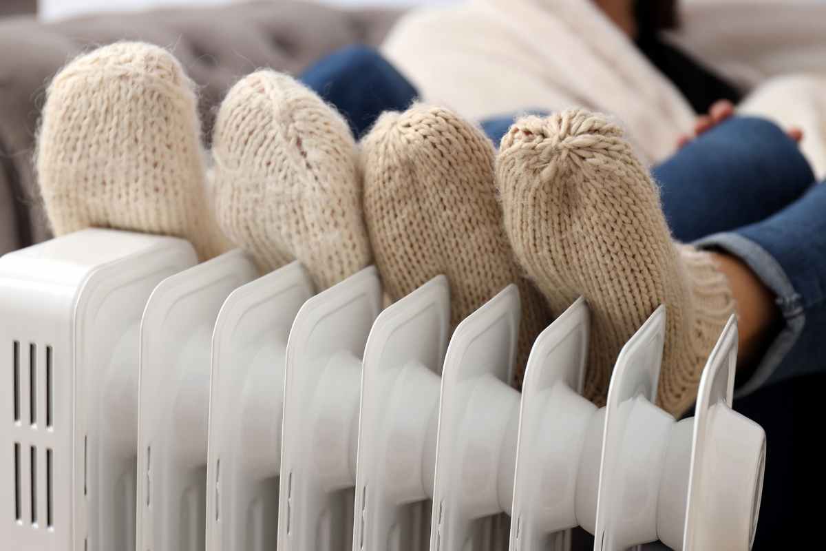 persone coi piedi sui termosifoni