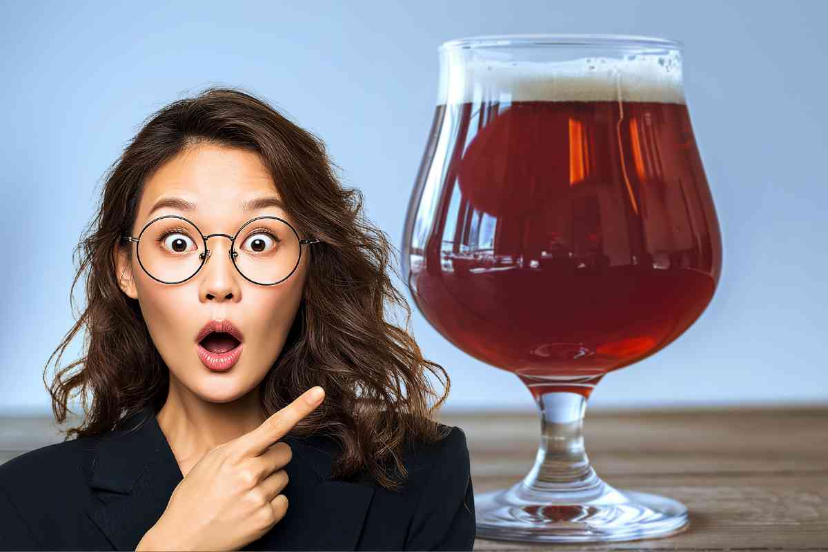 Donna indica un boccale di birra rossa