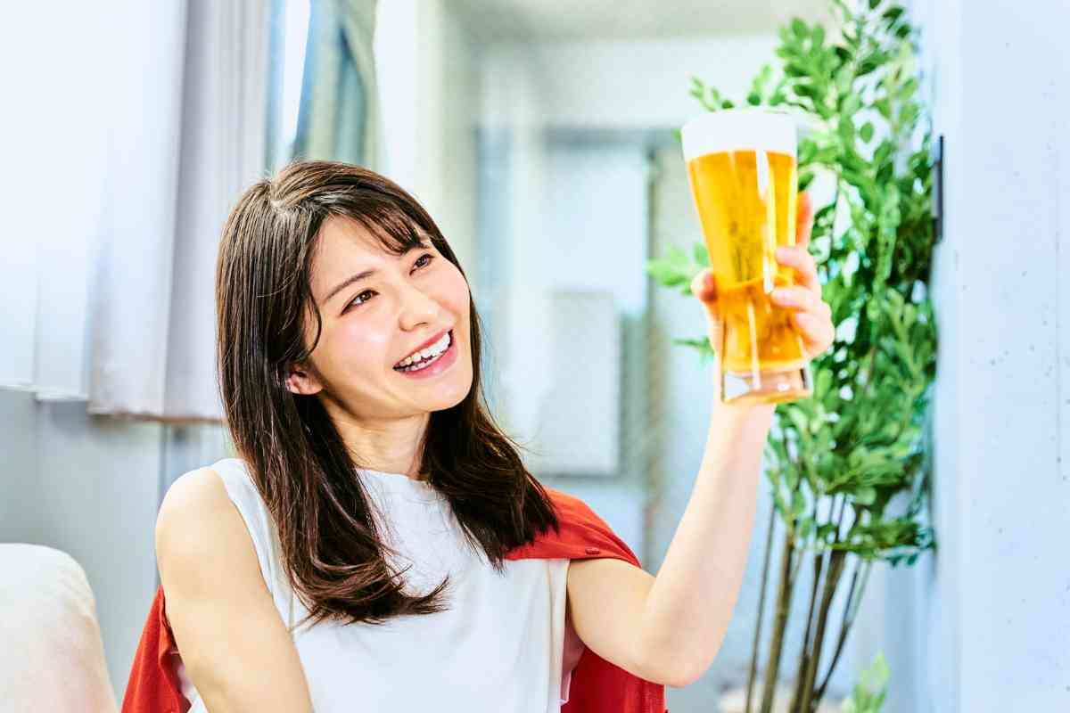 donna solleva un boccale di birra sorridendo