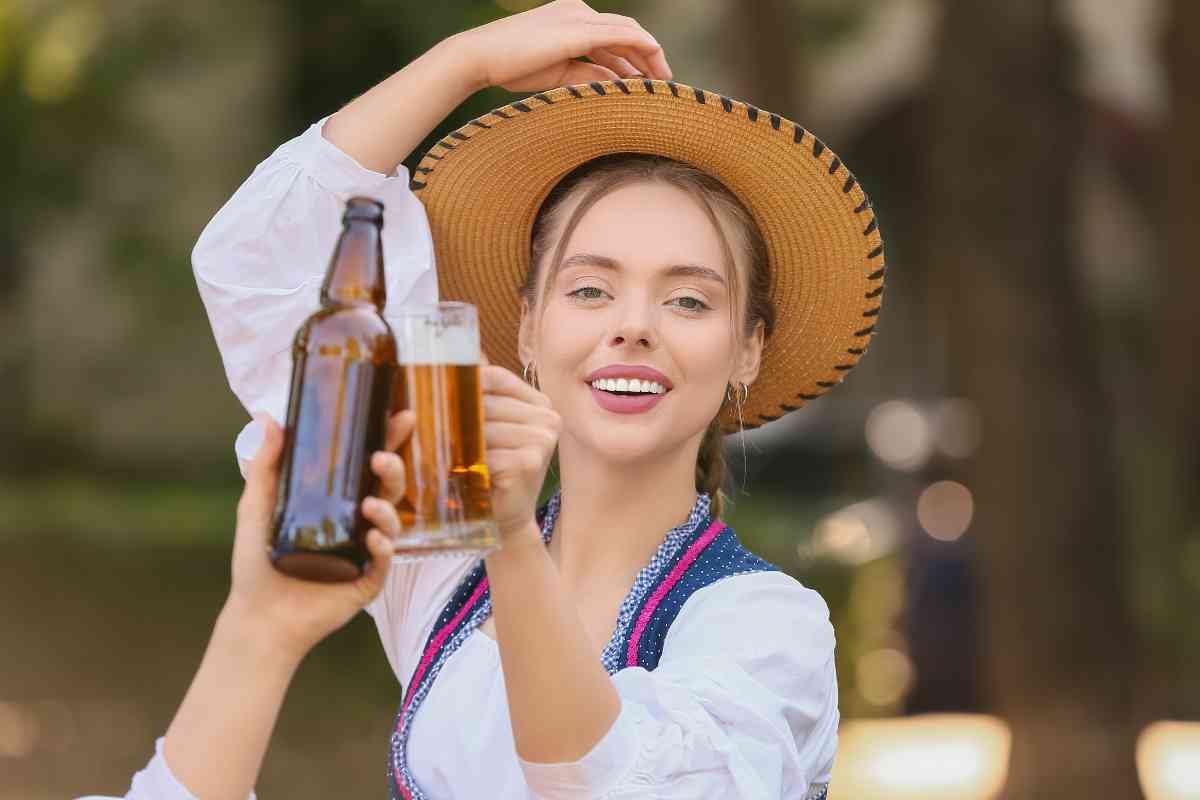 una ragazza brinda con una birra in boccale