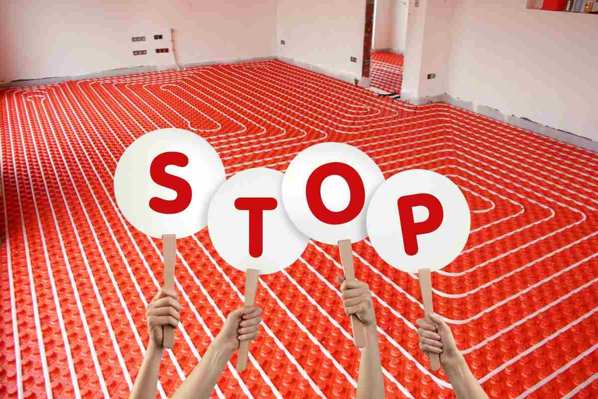 riscaldamento a pavimento e mani che mantengo cartelli con lettere che compongono la frase stop