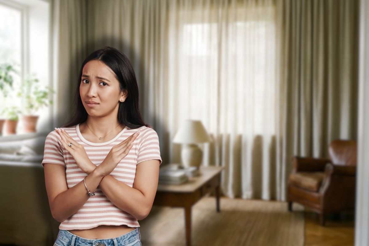 soggiorno con tende e donna che fa stop con le mani