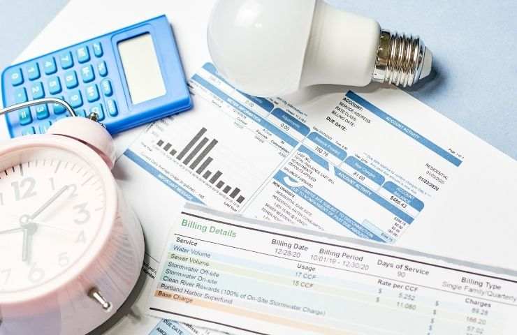 bollette utenze, lampadina e calcolatrice