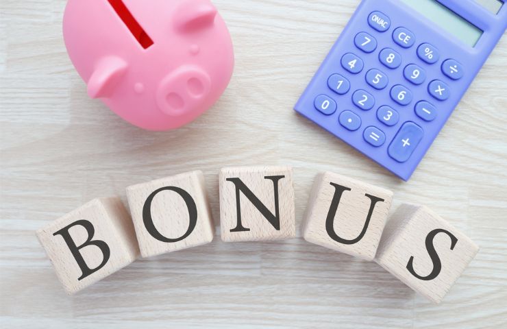 scritta bonus, salvadanaio a porcellino e calcolatrice