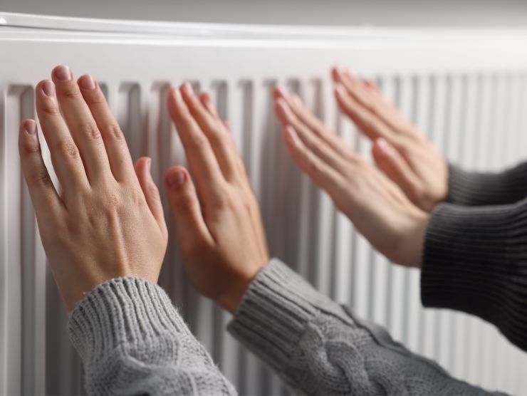 mani che toccano termosifone 