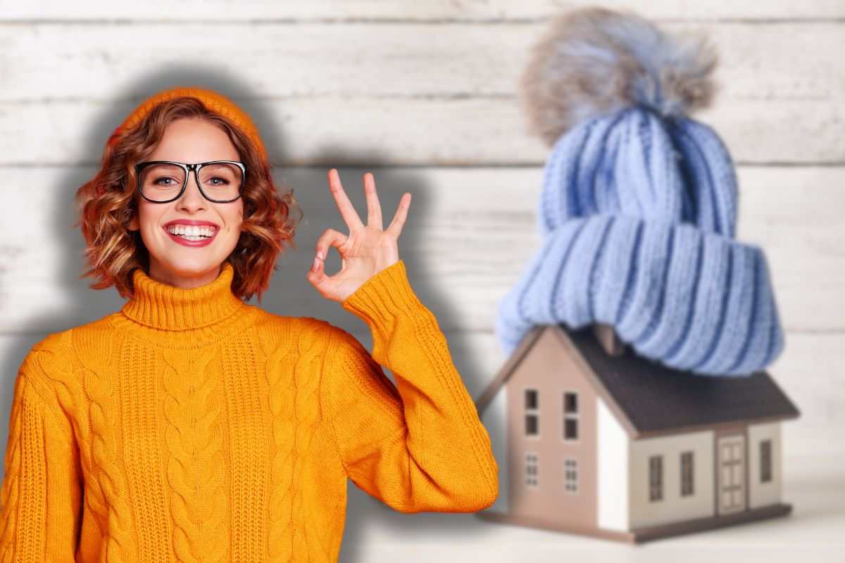 cappello di lana su sagoma di casa e donna sorridente che fa ok con le mani
