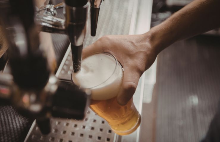 birra che viene versata nel bicchiere 