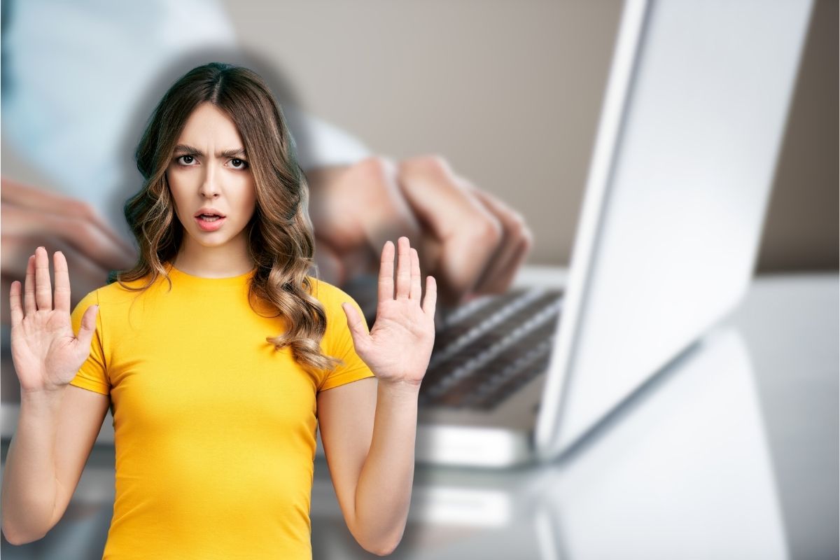 uomo al pc e donna che fa stop con le mani