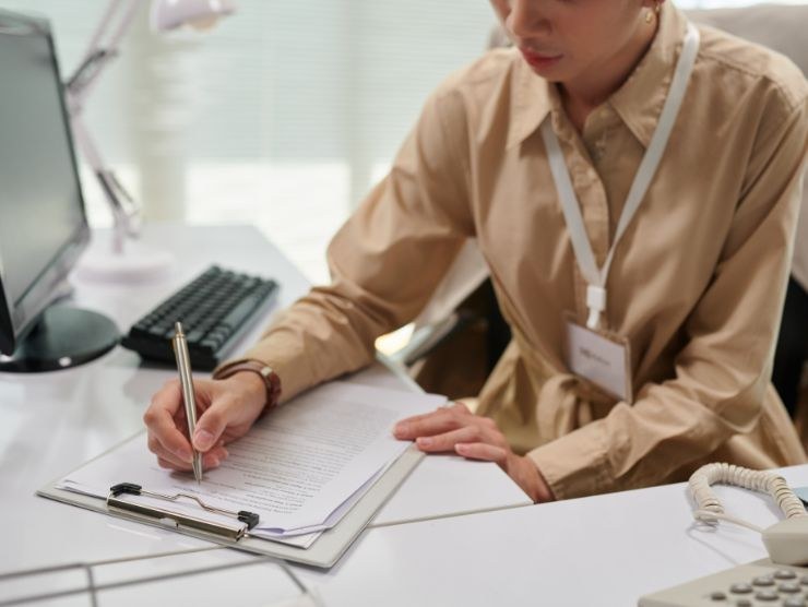 donna seduta ad una scrivania che compila documenti