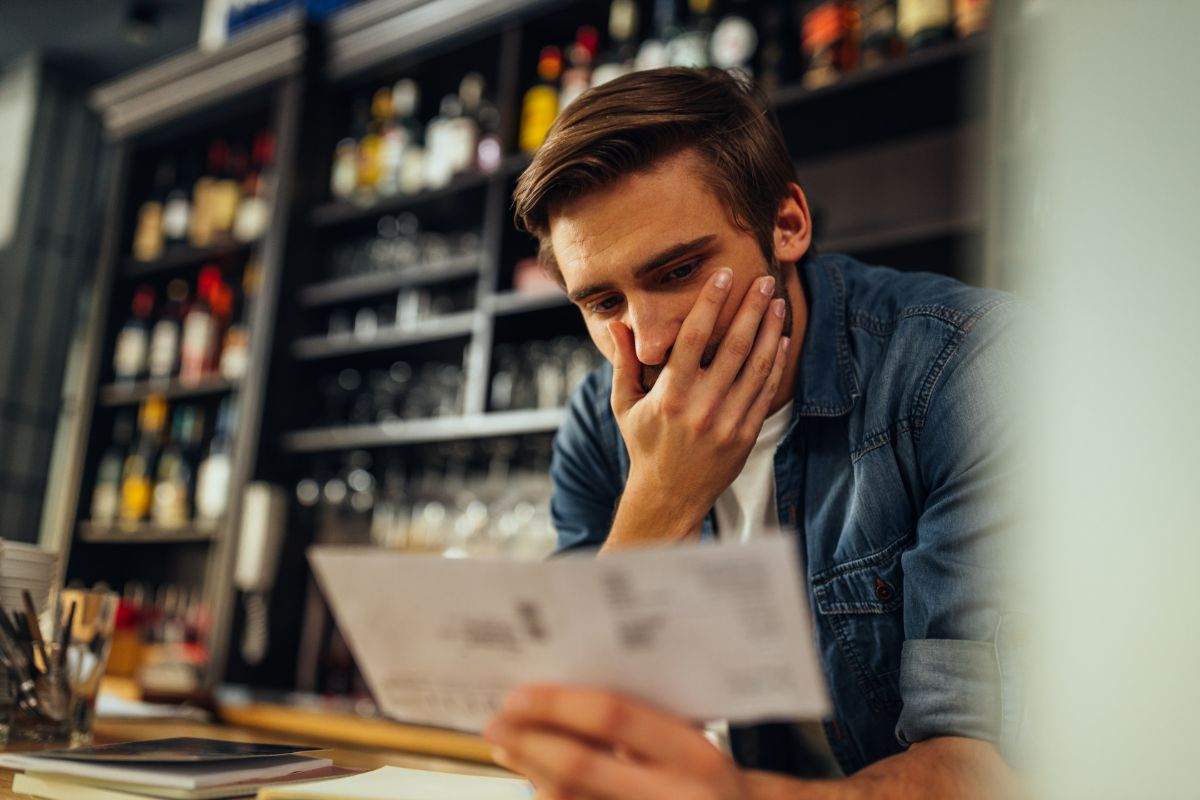 ragazzo che legge una bolletta