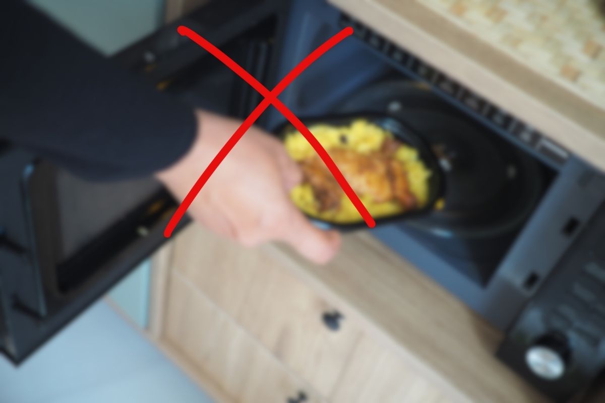 uomo che usa forno a microonde ed x rossa