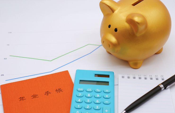 calcolatrice, penna e salvadanaio a porcellino