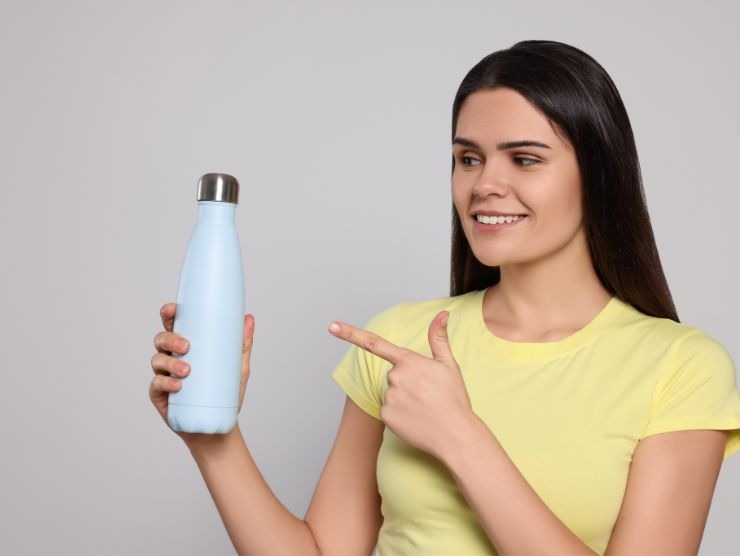 donna sorridente che impugna una borraccia