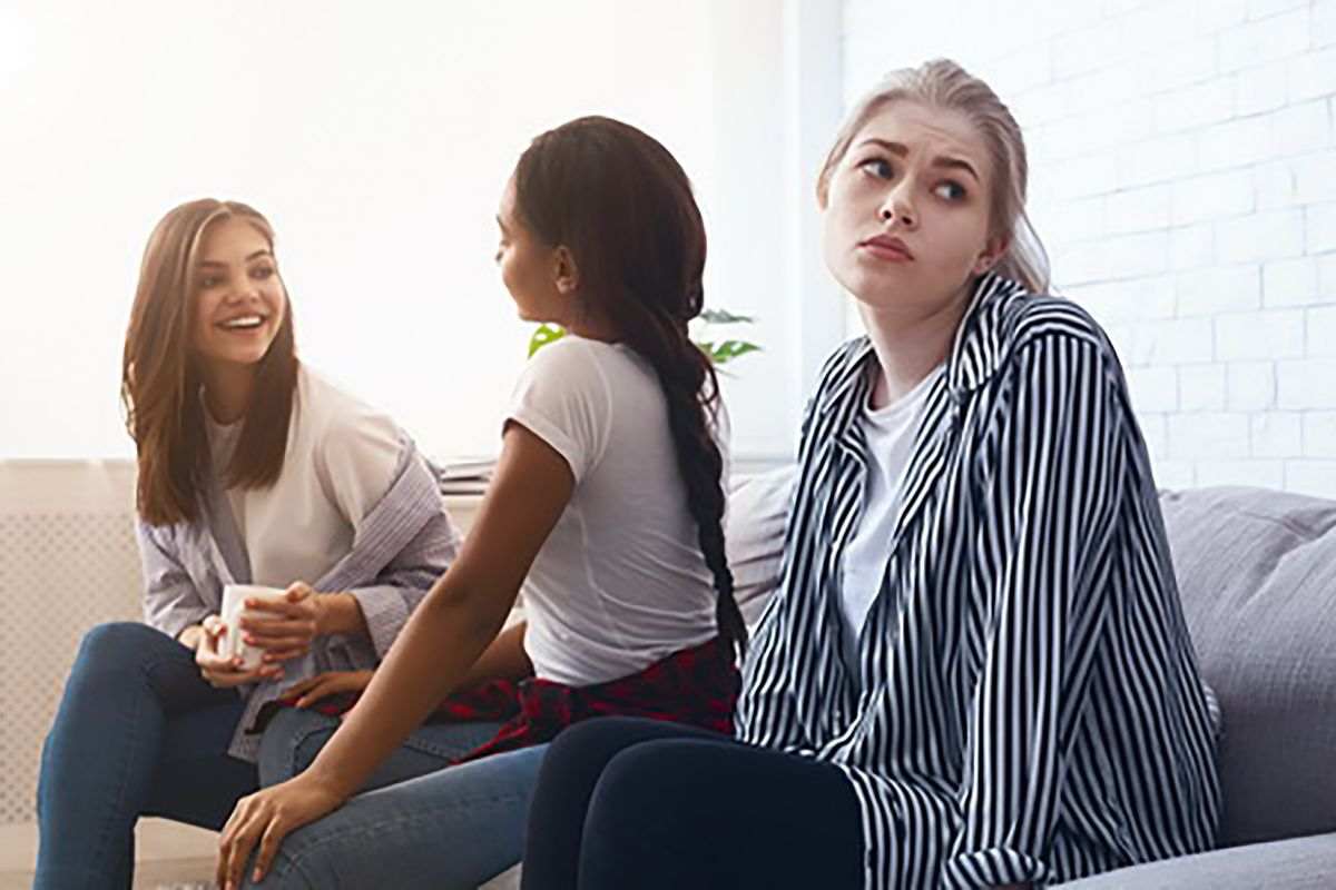 ragazze isolata da altre due ragazze sedute con lei sul divano