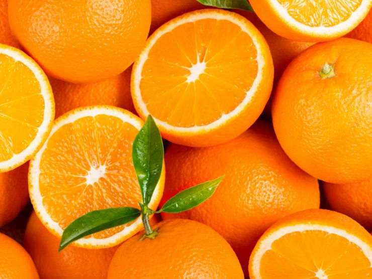 arancia tagliata a metà insieme ad altre arance