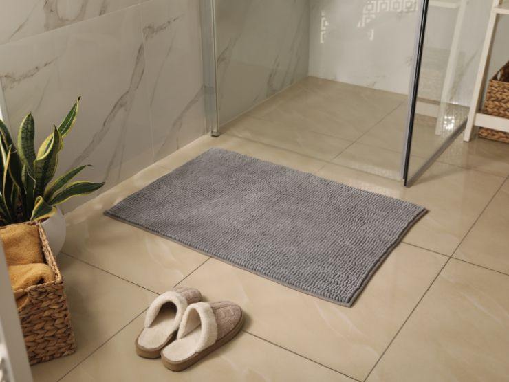 tappeto da bagno davanti ad una doccia con pantofole
