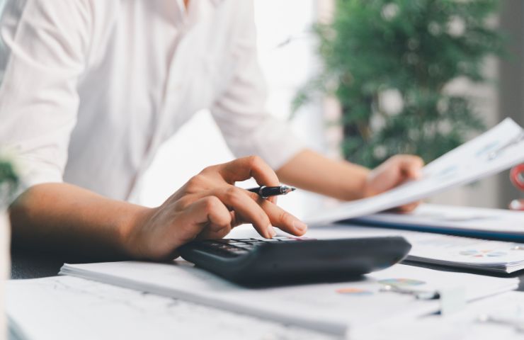 uomo che fa calcoli con la calcolatrice