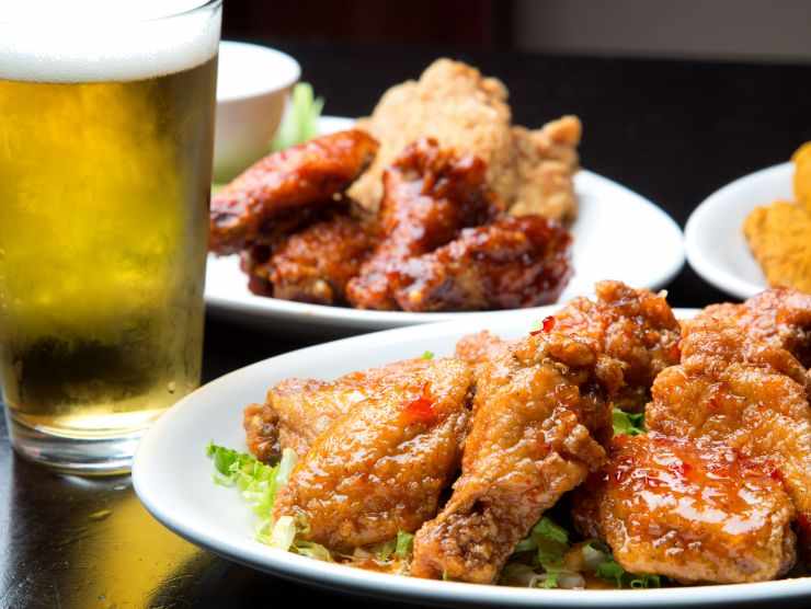 piatti di pollo cotto e boccale di birra