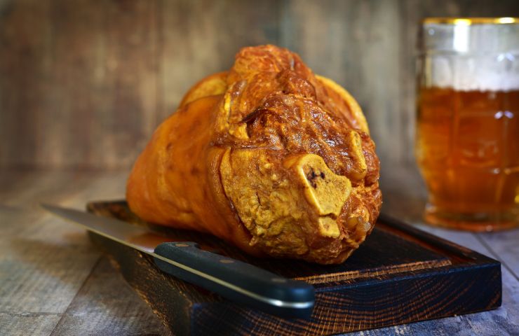 stinco di maiale nel piatto e birra 