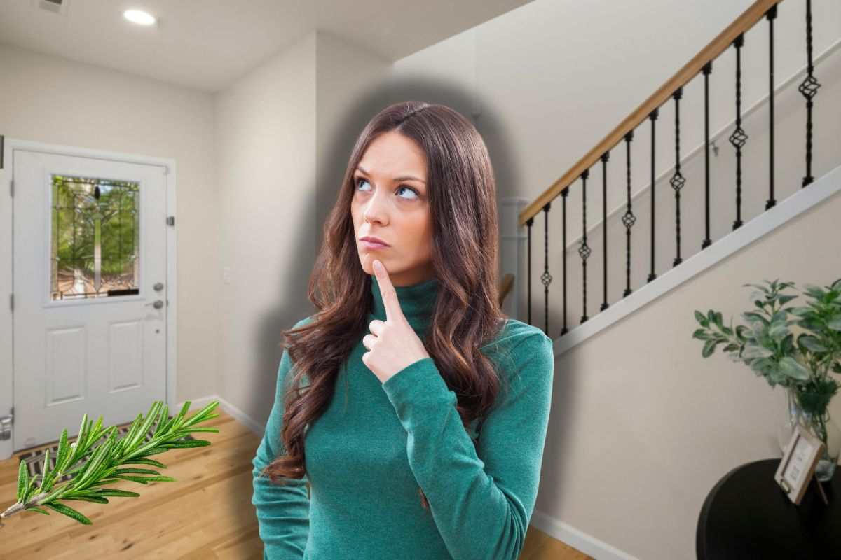 porta ingresso casa, fascetto di rosmarino sul tappeto e donna che pensa