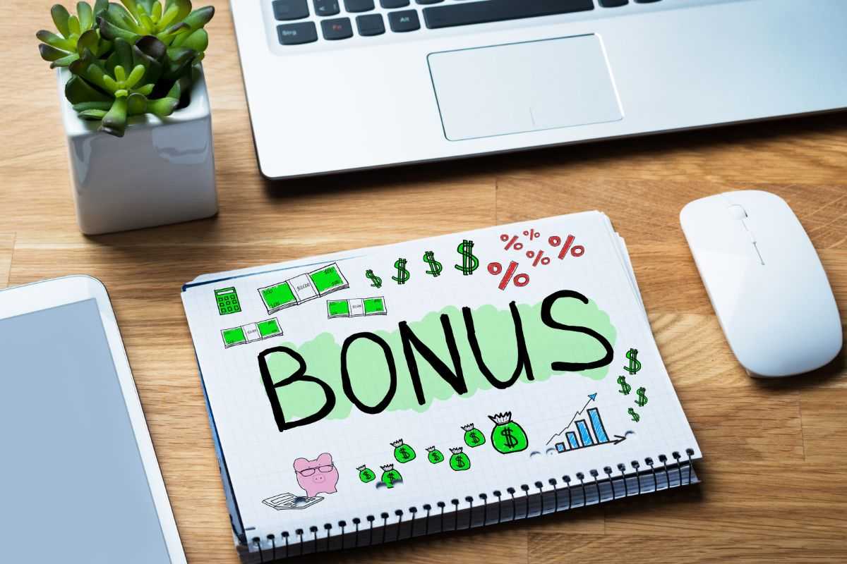 scritta bonus evidenziata in verde su quaderno poggiato su tavolo di legno