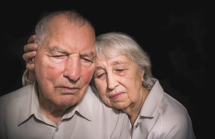 due persone anziane tristi che si abbracciano