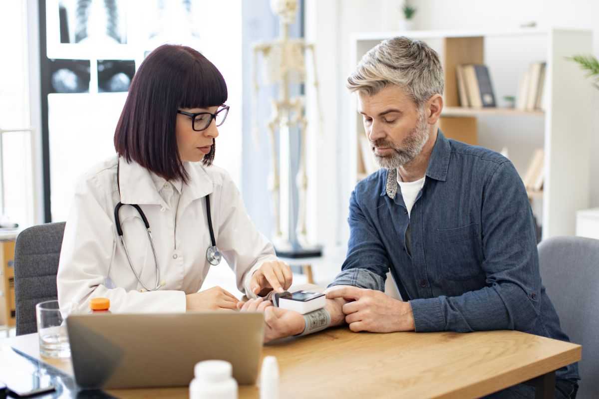 uomo che misura la pressione dalla dottoressa